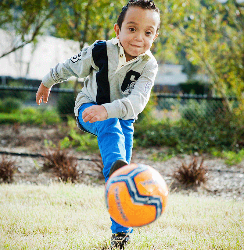 boy kicking football